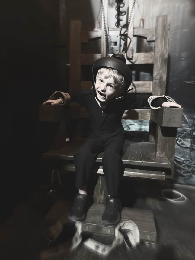 Backlot Experience electric chair prop at Little Shop of Horrors Costumery – child posing during guided movie set tour in Mornington