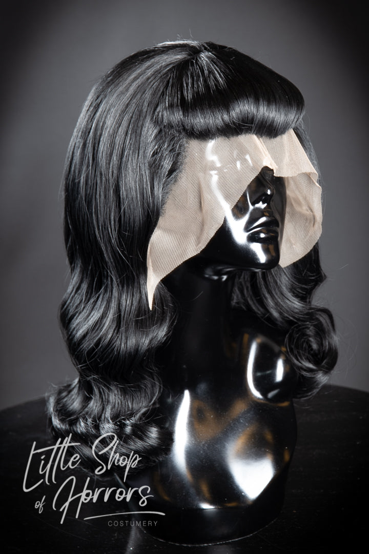 Paying homage to the one and only, the Notorious Bettie Page, who "never was the girl next door". Often referred to as the Queen of Pinups, her liberated sexuality and iconic look has influenced style for generations. This wig is a Bettie Page themed vintage 1950s pinup style with of course, those iconic bangs. Available to order at Little Shop of Horrors Costumery & Pop Culture Emporium, Melbourne's Wig Styling Specialists. 6/1 Watt Rd Mornington.