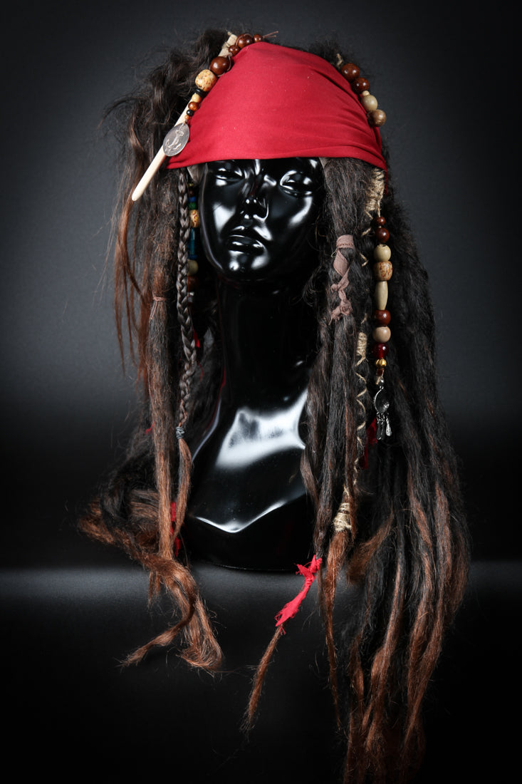 Become a legendary pirate of the Seven Seas, an irreverent trickster and captain of equally dubious morality and sobriety. Our "Jack Sparrow Wig" will be the hero piece of your Jack Sparrow costume. Handcrafted two toned dredlocks, plaits, beads and topped off with a bandana.Available to order at Little Shop of Horrors Costumery & Pop Culture Emporium, Melbourne's Wig Styling Specialists. 6/1 Watt Rd Mornington.