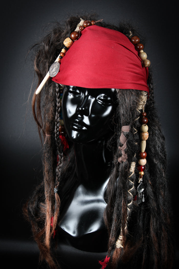 Become a legendary pirate of the Seven Seas, an irreverent trickster and captain of equally dubious morality and sobriety. Our "Jack Sparrow Wig" will be the hero piece of your Jack Sparrow costume. Handcrafted two toned dredlocks, plaits, beads and topped off with a bandana.Available to order at Little Shop of Horrors Costumery & Pop Culture Emporium, Melbourne's Wig Styling Specialists. 6/1 Watt Rd Mornington.